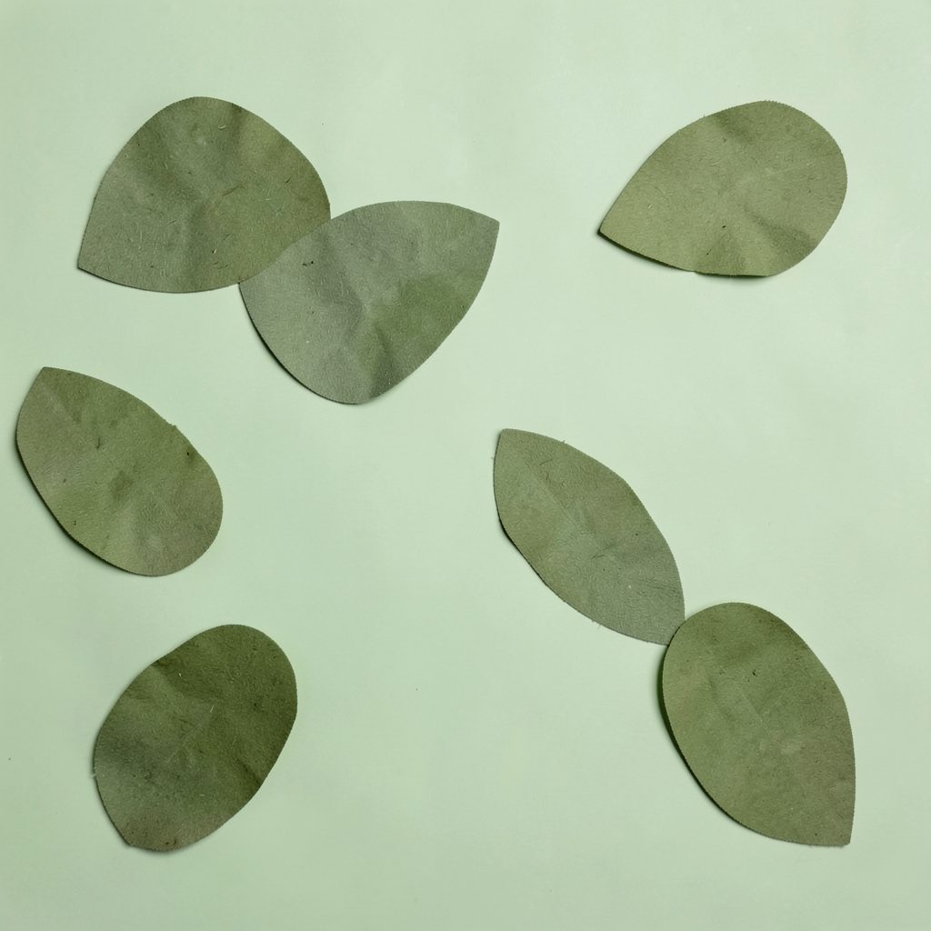 Soft abstract leaf shapes in muted olive green, scattered loosely across a light green background, conveying calm and natural wellbeing